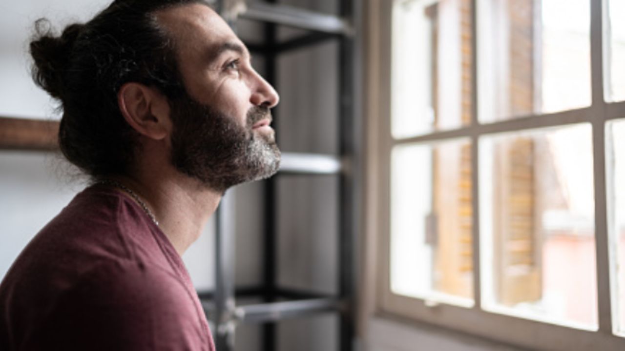 persona che guarda fuori dalla finestra