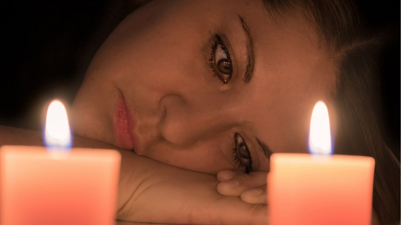 donna con volto illuminato dalle candele